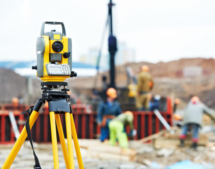 Surveying measuring equipment theodolite transit on tripod at construction building area site
